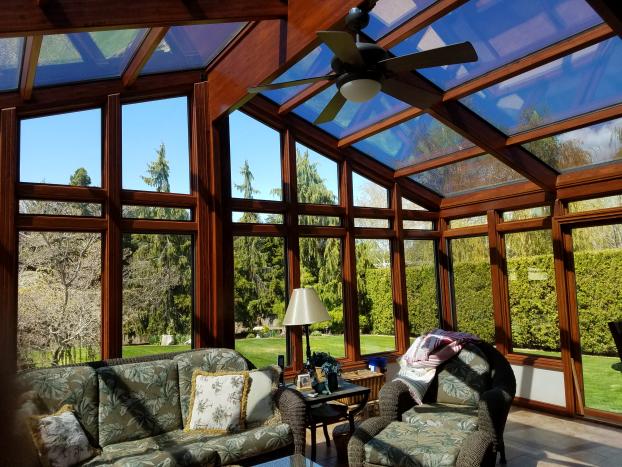A beautiful photo of a sunroom with views into a lush yard.